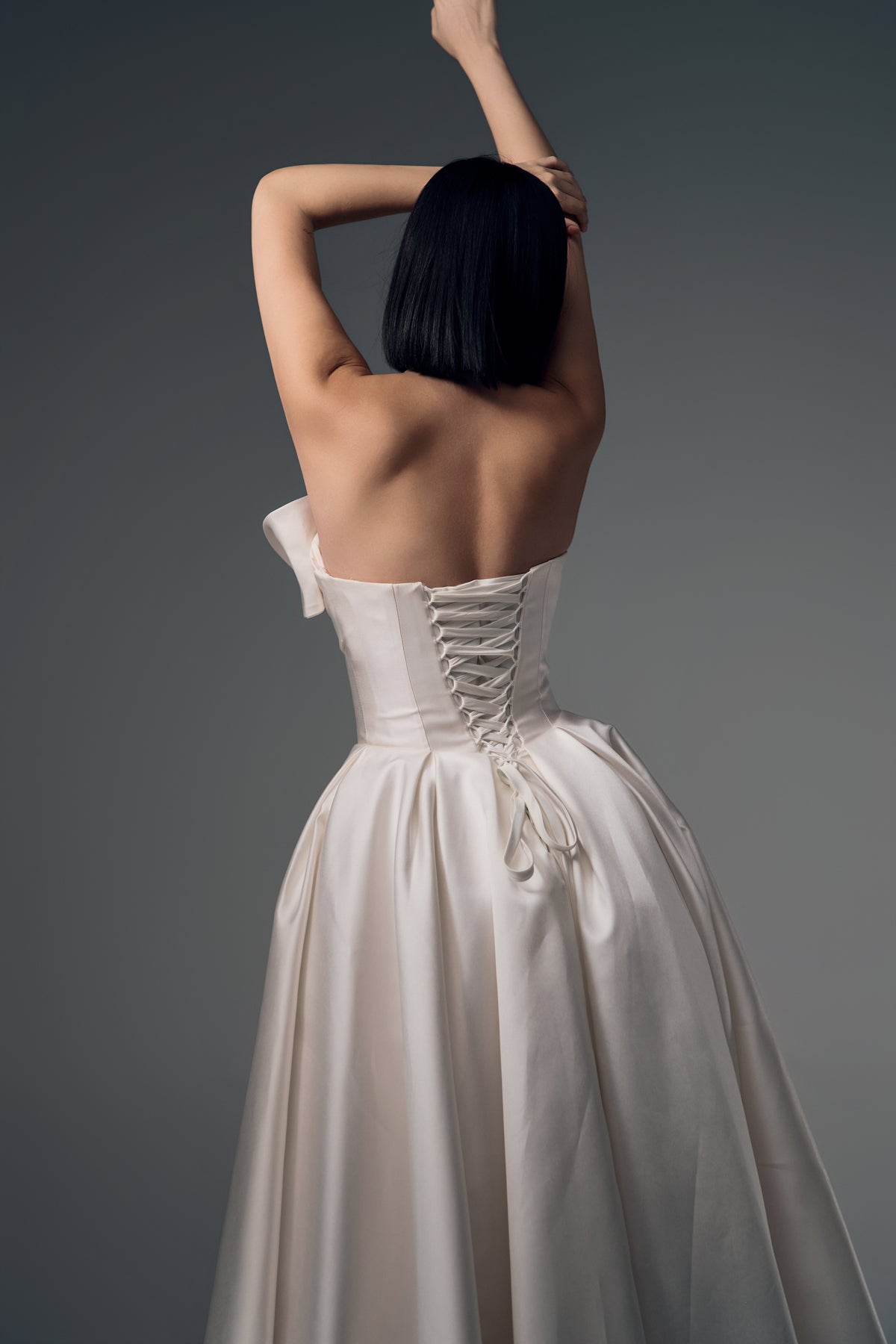 Lunara one-shoulder origami satin A-line wedding dress, lace-up back view