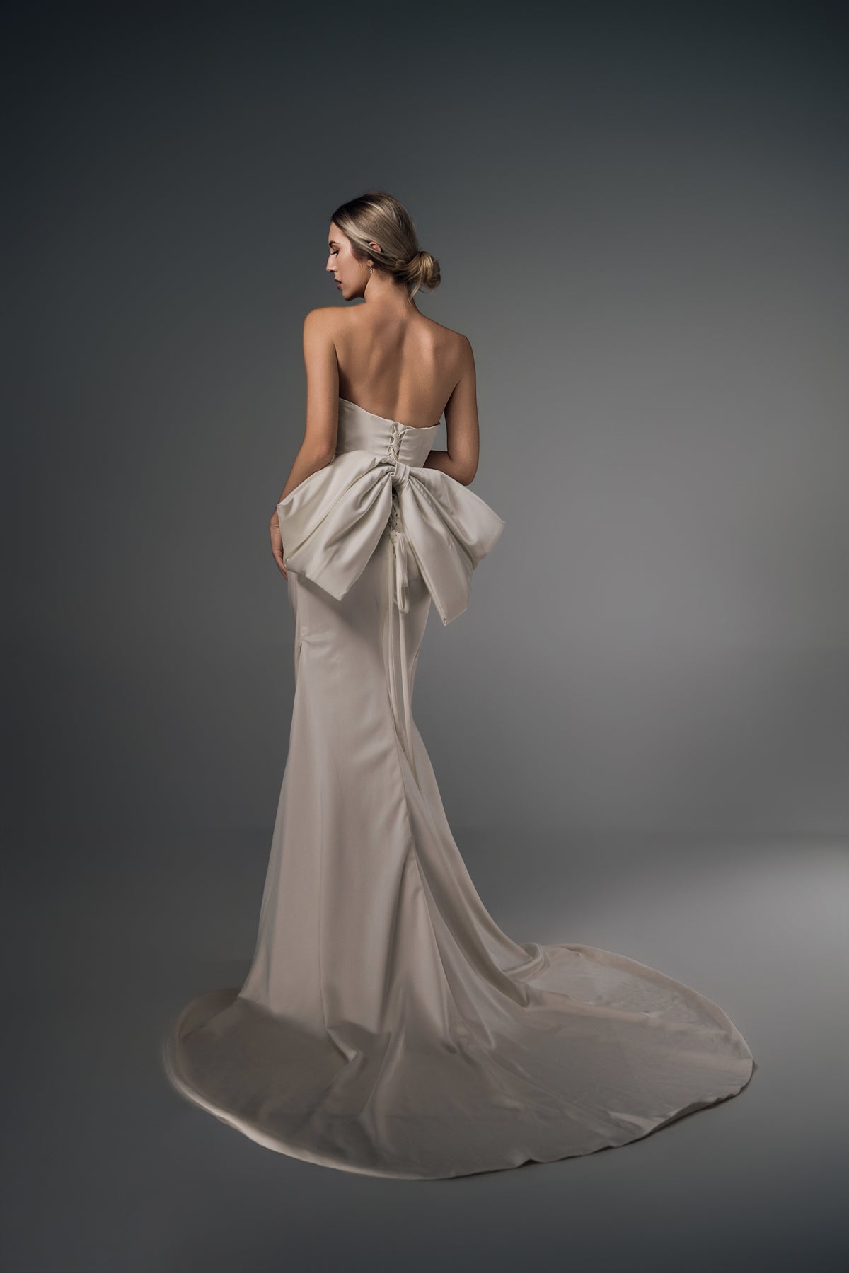 Nerina ruched satin mermaid wedding dress, bow-back train view