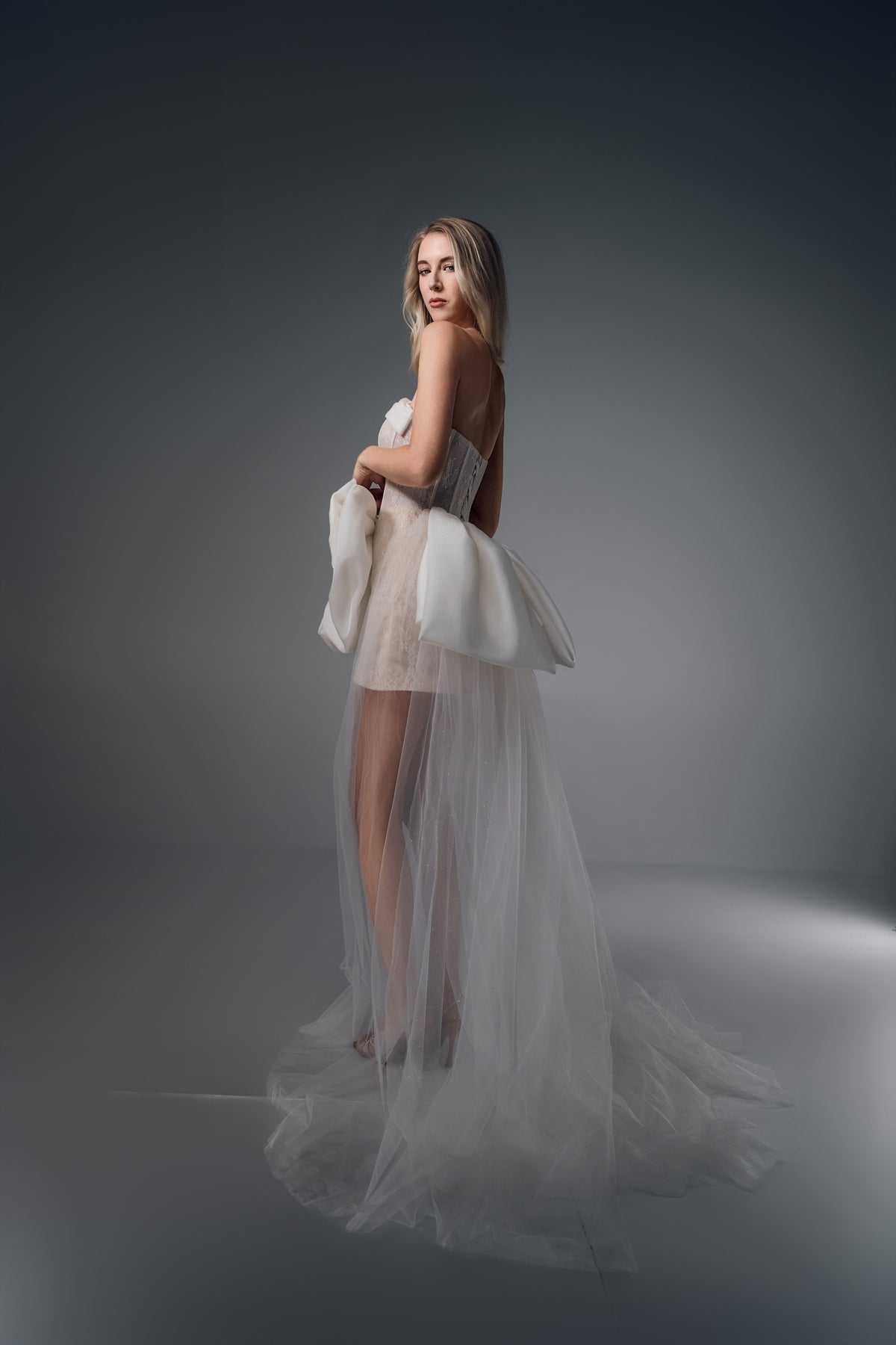 Novella sheer-bodice mini wedding dress with bow train, train view